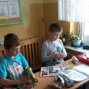 pokaż obrazek - Uczniowie wykonują kotki z odpadów.