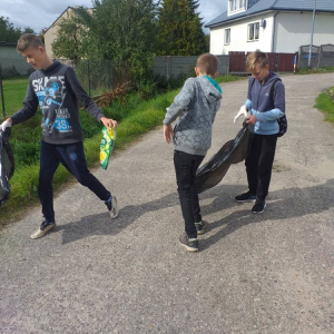 pokaż obrazek - Uczniowie zbierają śmieci przy drodze