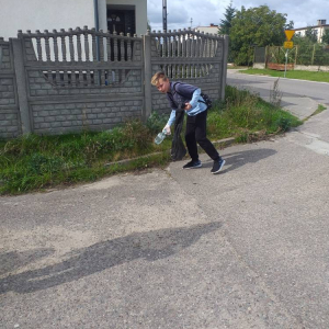 pokaż obrazek - Uczeń zbiera śmieci przy drodze