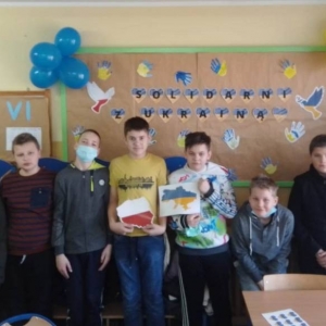 pokaż obrazek - Uczniowie na tle gazetki