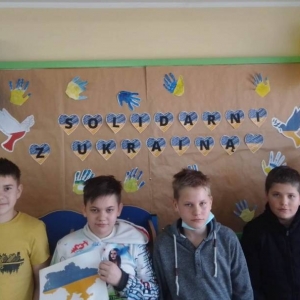 pokaż obrazek - Uczniowie na tle gazetki