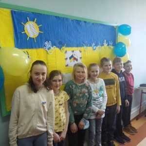 pokaż obrazek - Uczniowie na tle gazetki