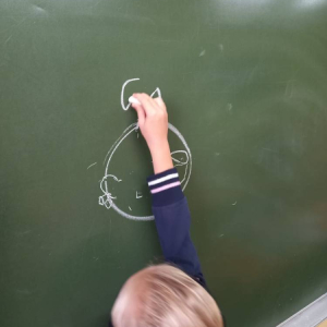 pokaż obrazek - Dziecko rysuje na tablicy