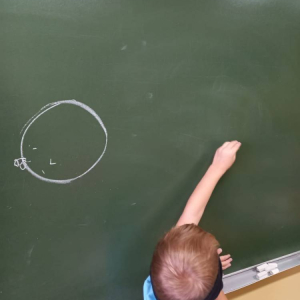 pokaż obrazek - Dziecko rysuje na tablicy