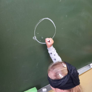 pokaż obrazek - Dziecko rysuje na tablicy