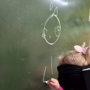 pokaż obrazek - Dziecko rysuje na tablicy
